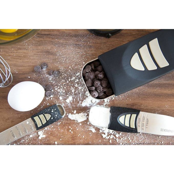 Adjustable measuring spoons and scoop with sliding measurement indicators, surrounded by flour, chocolate chips, and an egg, ideal for Kitchen & Food, Food Prep, and Measuring collections.
