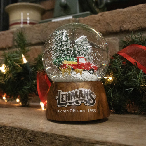 Handcrafted musical snow globe featuring a red truck with a tree and two dogs inside, set on a wooden base, perfect for Home & Decor, Holiday Decor, and Best Sellers collections.