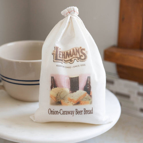 Natural cotton drawstring bag displaying handcrafted onion-caraway beer bread mix with rustic branding, ideal for Kitchen & Food, Pantry, Dry Goods and Mixes, Best Sellers, and Promo Eligible collections.