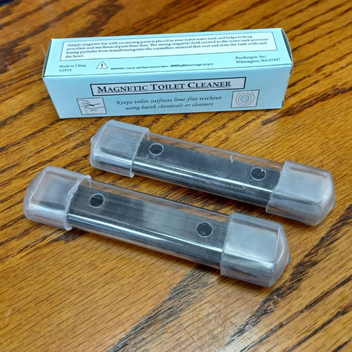 Two clear plastic housings each containing long-lasting magnets designed to prevent mineral buildup and stains in toilet tanks, placed on a wood surface, featured in Home & Decor and Household Cleaning collections.