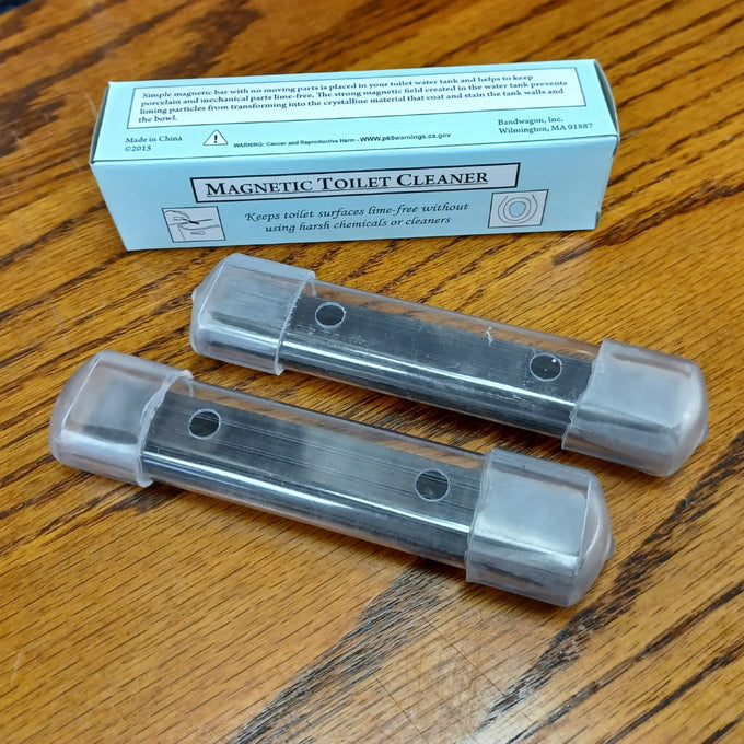 Two clear plastic housings each containing long-lasting magnets designed to prevent mineral buildup and stains in toilet tanks, placed on a wood surface, featured in Home & Decor and Household Cleaning collections.
