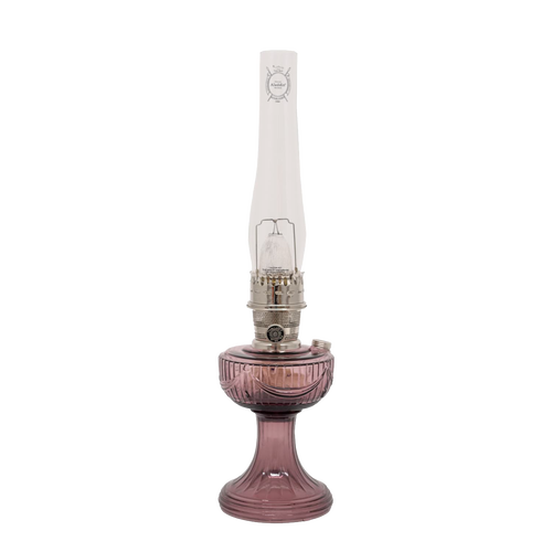 Handcrafted glass oil lamp with a rose-tinted Lincoln Drape base, tall clear chimney bearing embossed logo, and polished brass burner, ideal for Farm, Garden & Tool, Lamps & Lighting, Oil Lamps, Table Lamps, Best Sellers, Homesteading, and Promo Eligible collections.