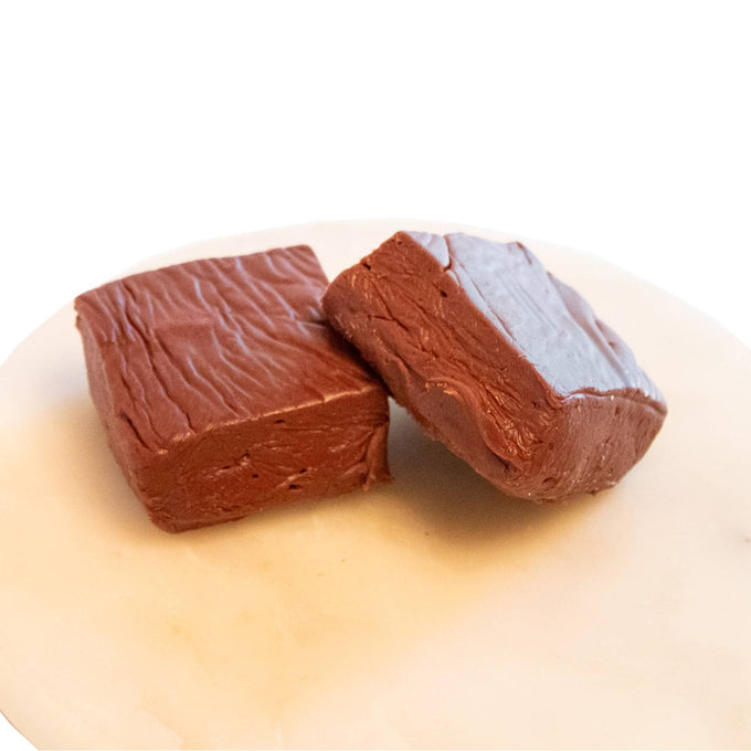 Two handcrafted rich chocolate fudge pieces with smooth texture resting on a white plate, featured in Kitchen & Food, Snacks and Sweets, USA Made, Best Sellers, and Promo Eligible collections.