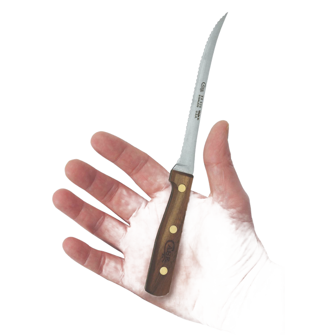 Hand holding a small serrated kitchen knife with a wooden handle, designed for slicing tomatoes and vegetables, crafted in the USA from high-quality materials.