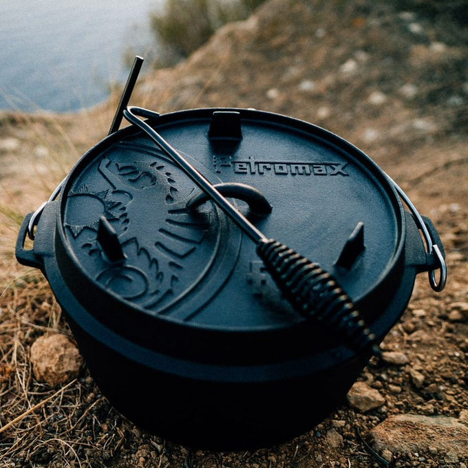 Petromax Dutch oven with sturdy cast iron lid and curved metal lifter with coiled handle, ideal for safe outdoor cooking, featured in Farm, Garden & Tool, Camping, Best Sellers, and Promo Eligible collections.