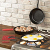 Cast iron skillet and griddle with cooked eggs and cinnamon rolls on a stovetop with silicone handle and pot holders, highlighting durable cookware for kitchen and homesteading use.