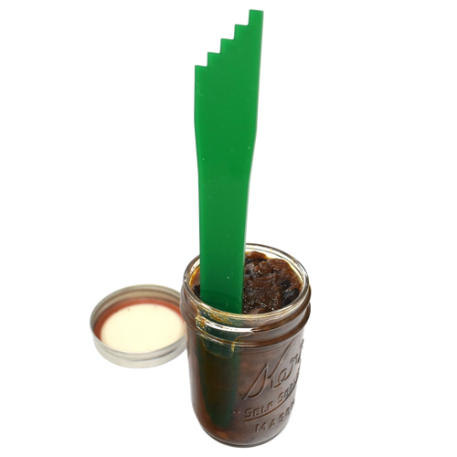 Handcrafted green jar spatula with multiple notch sizes for lifting and adjusting canning jar lids, shown inside a glass canning jar filled with preserves, perfect for Food Preservation, Canning, Kitchen & Food collections.