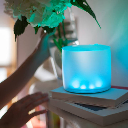 Soft blue glow of a compact, inflatable solar LED light placed on stacked books indoors, highlighting its eco-friendly design for camping, garden, and emergency use.