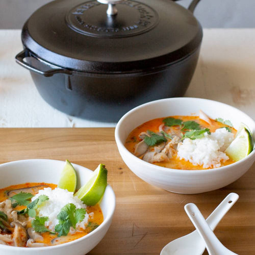 Handcrafted cast iron deep skillet with lid, triple seasoned for a durable nonstick surface, shown with bowls of vibrant stew garnished with cilantro and lime, ideal for Kitchen & Food, Cookware, Cast Iron, USA Made, Best Sellers, and Promo Eligible collections.