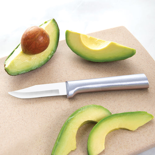 Sharp carbon stainless steel paring knife with a satin-finished cast aluminum handle lying on a cutting board next to fresh avocado slices in a kitchen food prep setting, ideal for USA made collections.