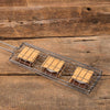 Handcrafted steel basket designed to toast three s’mores simultaneously, featuring graham crackers, chocolate, and marshmallows, ideal for Farm, Garden & Tool, Camping, and Best Sellers collections.