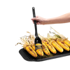 Hand applying glaze with a flexible black basting brush featuring a deep scooping head over charred corn on the cob on a cast iron grill pan, ideal for Kitchen & Food and Grilling collections.