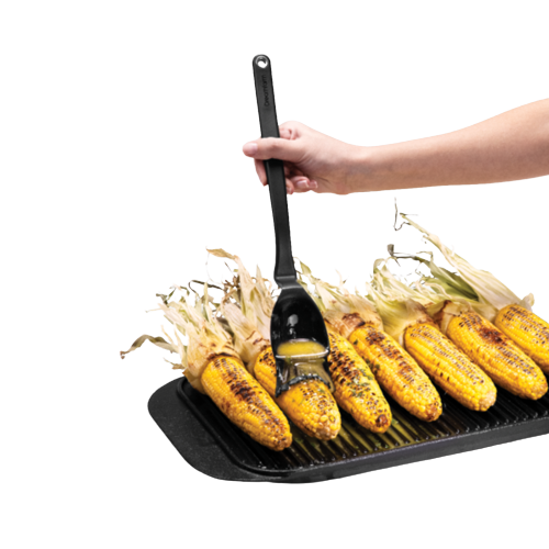 Hand applying glaze with a flexible black basting brush featuring a deep scooping head over charred corn on the cob on a cast iron grill pan, ideal for Kitchen & Food and Grilling collections.