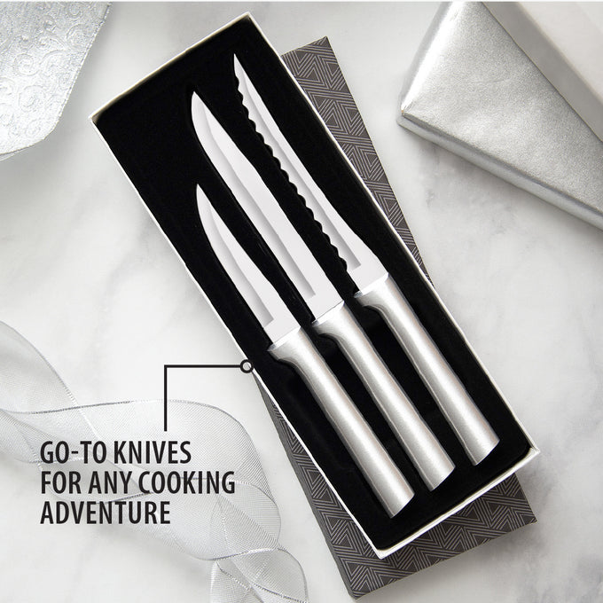 Three-piece set of sharp knives with sleek silver handles in a black gift box, including heavy-duty paring, utility, and serrated tomato slicer knives, handcrafted in the USA.