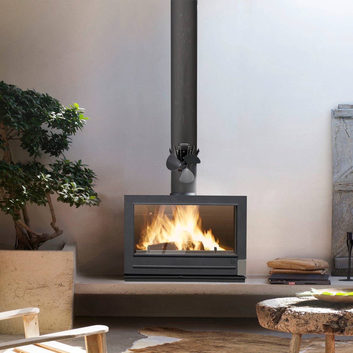 Black three-bladed heat-powered magnetic fan mounted on a stove flue pipe above a wood-burning stove, designed to circulate warm air efficiently in Stoves, Hearth Accessories, Best Sellers, Promo Eligible, and All Stoves & Appliances collections.