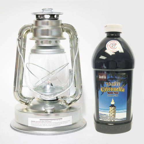 Silver metal oil lantern with clear glass globe next to a large black plastic bottle of citronella fuel, designed for outdoor use in pest control, camping, and farm or garden settings.
