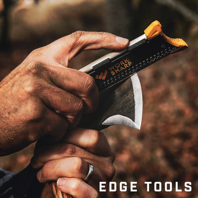 Close-up of a hand using a compact, black and orange pocket knife sharpener to sharpen a curved blade, suitable for Farm, Garden & Tool, Hand Tools and Hardware, and Sharpening collections.