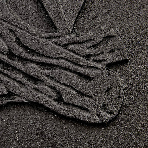 Close-up of a handcrafted cast iron stove door panel featuring detailed embossing of stacked logs, designed for use in stoves, hearth accessories, and heatstoves collections.