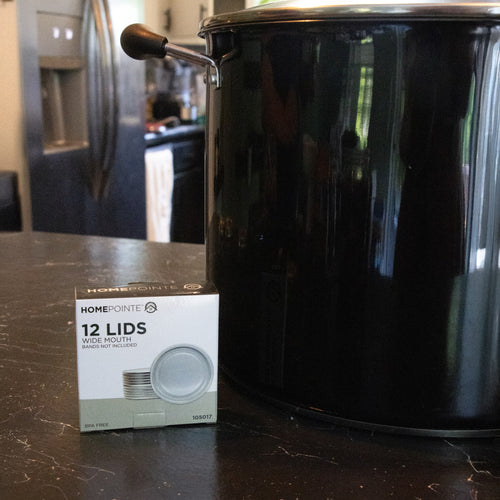 Box of twelve wide-mouth canning lids with BPA-free sealing compound displayed beside a large black enamel canning pot, ideal for Kitchen & Food, Food Preservation, and Canning collections.