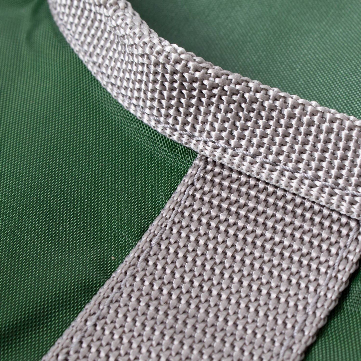 Close-up of a durable woven beige strap attached to a dark green Amish clothespin bag, handcrafted in the USA, ideal for laundry and clothesline use in home and decor collections.