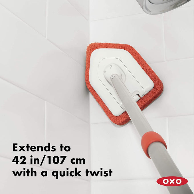 Extendable scrubber with an antimicrobial abrasive head and ergonomic handle, designed for cleaning tub and tile corners, part of Home & Decor and Household Cleaning collections.