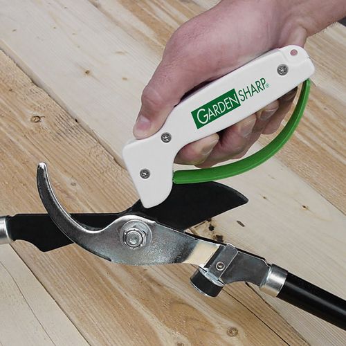 Handheld garden tool sharpener with white body and green handle, designed to quickly sharpen pruning shears and other farm and garden tools, crafted in the USA for lawncare and best sellers collections.
