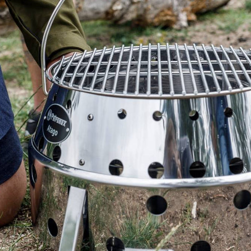 Stainless steel replacement grilling grate with a 13.4-inch diameter set on a portable outdoor grill, perfect for camping, backyard grilling, and Farm, Garden & Tool collections.
