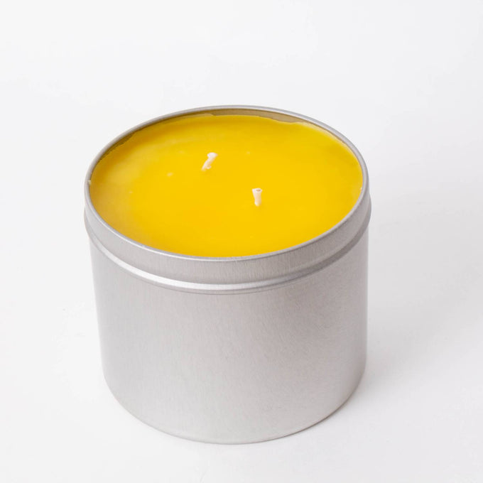 Hand-poured bright yellow citronella candle with two wicks in a compact silver tin, handcrafted for outdoor use in camping, pest control, and garden lighting collections.