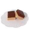 Two handcrafted pieces of creamy two-tone fudge with rich chocolate tops and light brown bottoms, presented on a delicate white lace paper, ideal for snacks and sweets collections.