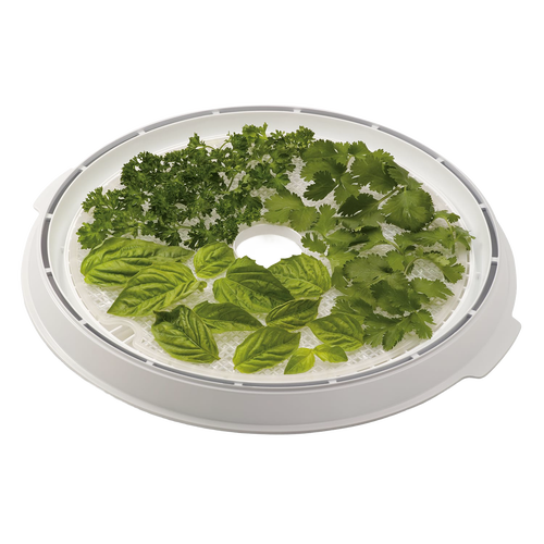 Round flexible drying screen placed on dehydrator tray with fresh herbs arranged on top, designed to prevent small food items from falling through, ideal for kitchen and food preservation use.
