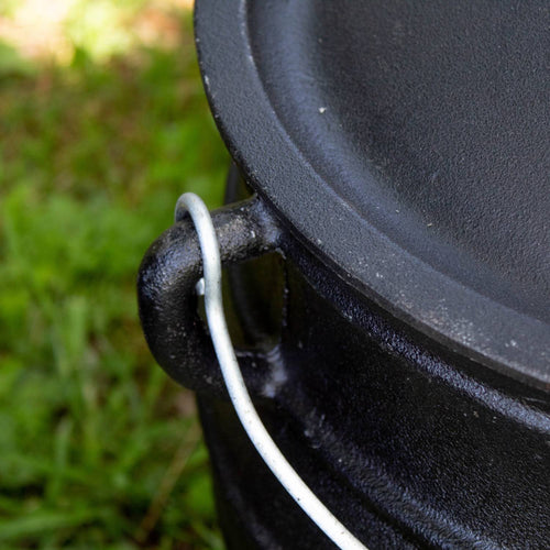 Close-up of a handcrafted cast iron campfire kettle’s sturdy wire bail handle attached to the thick rounded rim, designed for long-lasting outdoor use in Farm, Garden & Tool, Camping, Best Sellers, and Promo Eligible collections.