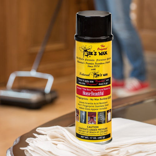 Tall yellow can of beeswax furniture polish with black cap, featuring detailed product information, placed on a white cloth in a home cleaning setting, part of Home & Decor and Household Cleaning collections.