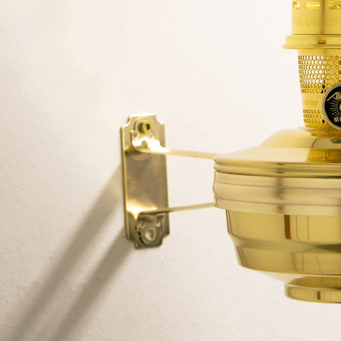 Handcrafted solid brass wall-mounted oil lamp bracket securing a bright oil lamp, featured in Farm, Garden & Tool, Lamps & Lighting, and Emergency Supplies collections.