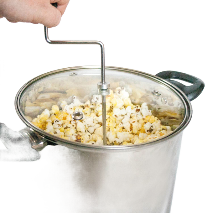 Stainless steel stovetop popcorn popper with glass lid, black handles, and hand crank stirring arm, handcrafted for fresh popcorn in Kitchen & Food and Cookware collections.