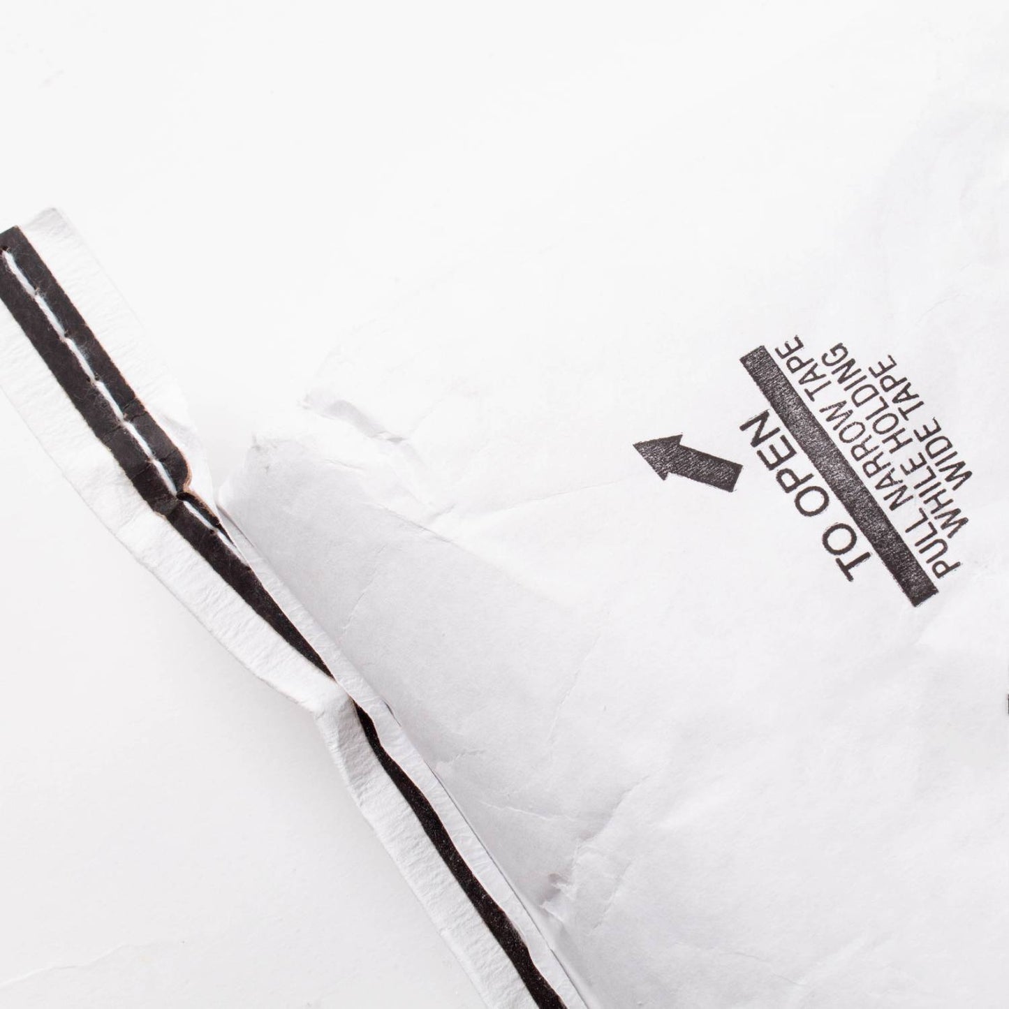 Partial view of a large white paper bag with printed opening instructions and black tape, used for packaging organic whole amaranth grain in Farm, Garden & Tool and Pantry collections.