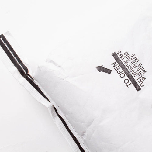 Partial view of a large white paper bag with printed opening instructions and black tape, used for packaging organic whole amaranth grain in Farm, Garden & Tool and Pantry collections.