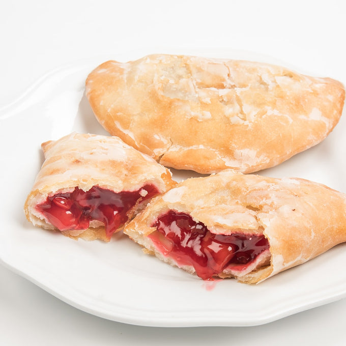 Handcrafted cherry-filled fry pies with golden flaky crust, showcasing a rich red filling, ideal for Kitchen & Food, Snacks and Sweets, USA Made, and Best Sellers collections.