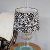 Black and white damask pattern cloth lamp shade designed for Aladdin oil lamps, shown on a clear glass lamp base in a cozy home setting, part of Lamps & Lighting collections.