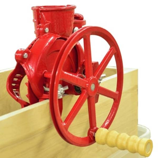 Handcrafted cast iron corn sheller in bright red with a wooden handle clamped to a wooden surface, designed for efficient grain shelling; part of Farm, Garden & Tool and Best Sellers collections.
