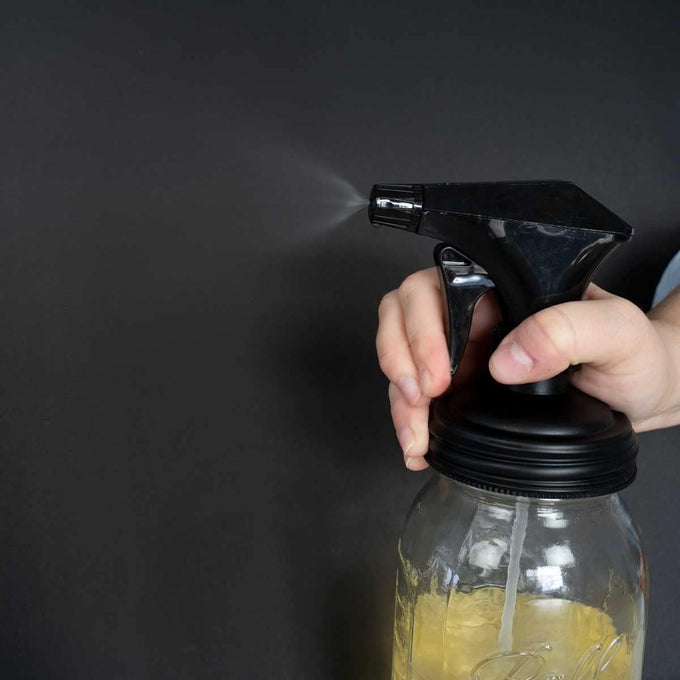 Hand pressing a black sprayer lid attached to a clear mason jar dispensing a fine mist, part of USA Made, Home & Decor, Household Helpers, Best Sellers, and Promo Eligible collections.