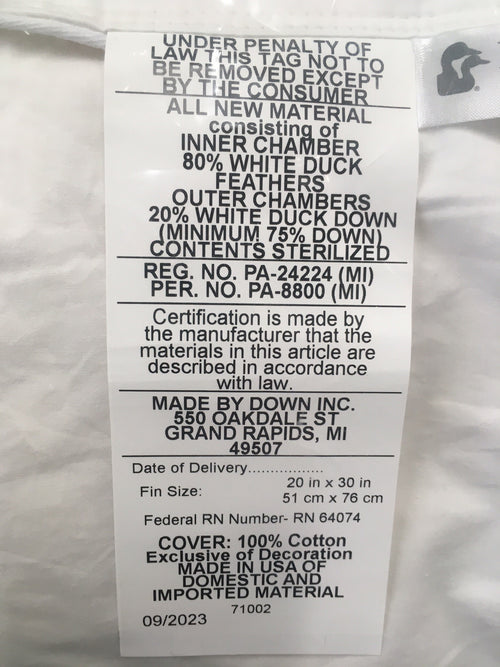 Close-up of a white cotton pillow label detailing fill of 80% white duck feathers inner core and 20% white duck down outer chambers, handcrafted in the USA, ideal for Home & Decor and Best Sellers collections.
