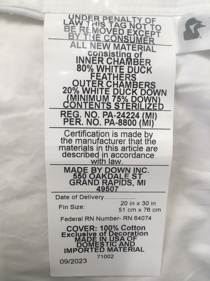 Close-up of a white cotton pillow label detailing fill of 80% white duck feathers inner core and 20% white duck down outer chambers, handcrafted in the USA, ideal for Home & Decor and Best Sellers collections.