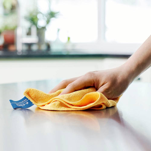 Hand holding a yellow microfiber cleaning cloth with thick fibers wiping a smooth countertop, ideal for chemical-free cleaning in Home & Decor and Household Cleaning collections.