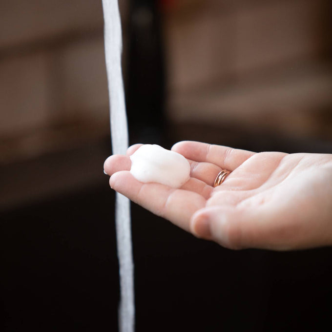 Hand holding rich foam from Lehman's handcrafted moisturizing foaming soap beneath running water, highlighting its natural oils and gentle cleansing in Health & Wellness and Soaps collections.