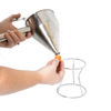 Person holding a stainless steel batter dispenser with thumb lever, attaching an interchangeable orange silicone tip above a white metal stand, part of Kitchen & Food and Cookware collections.