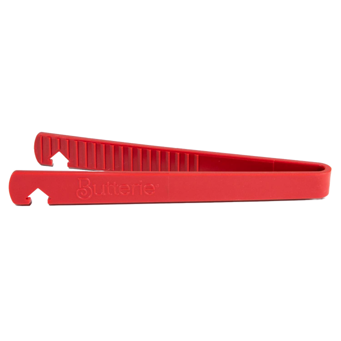 Side view of a red silicone toaster tong with serrated gripping teeth and integrated hook, designed for safe heat handling, featured in Kitchen & Food, Kitchen Gadgets, and Cooking and Baking Helpers collections.