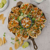 Handcrafted cast iron skillet filled with vibrant chicken tacos topped with fresh vegetables and cheese, garnished with lime wedges and surrounded by tortilla chips, ideal for Kitchen & Food, Cookware, Cast Iron, USA Made, Camping, and Farm, Garden & Tool collections.