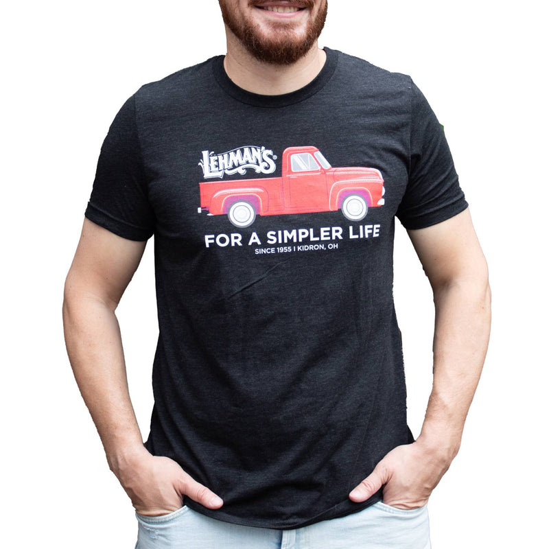 Adult wearing a charcoal soft cotton t-shirt featuring a bright red vintage truck graphic with Lehman's logo and "For a Simpler Life" text, ideal for Clothing and Accessories and Best Sellers collections.