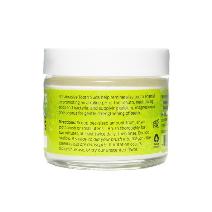 Clear jar of peppermint brushing soap tooth suds with bright green label detailing nonabrasive, enamel-strengthening formula, part of USA made health and wellness grooming collection.