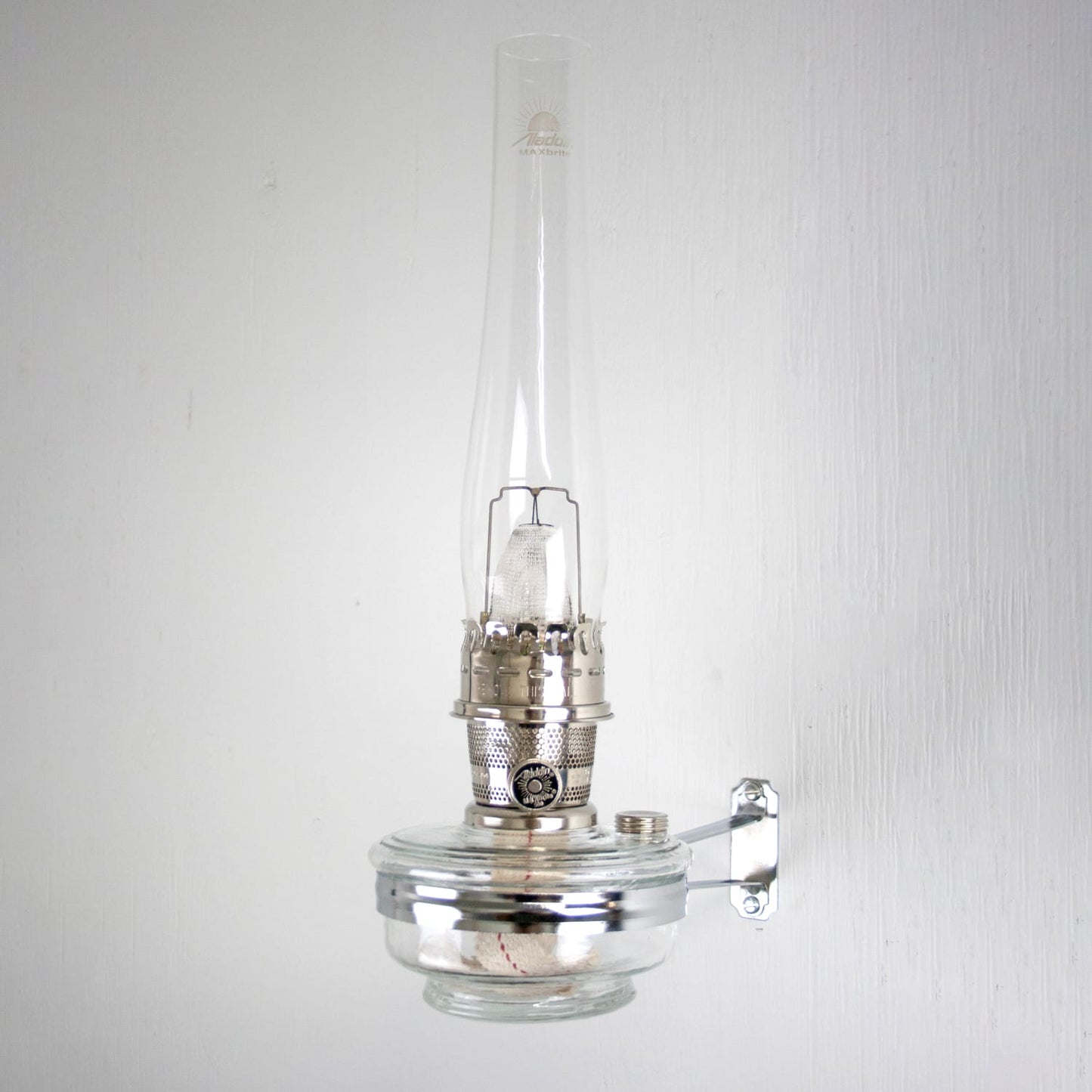 Handcrafted clear wall-mounted oil lamp with polished metal burner and tall glass chimney, designed for bright, space-saving illumination in Farm, Garden & Tool, Lamps & Lighting, Emergency Supplies, and Wall Lamps collections.